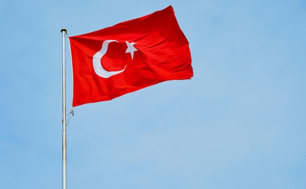 Flagge der Republik Türkei flattert im Wind vor blauem Himmelshintergrund mit Kopierraum