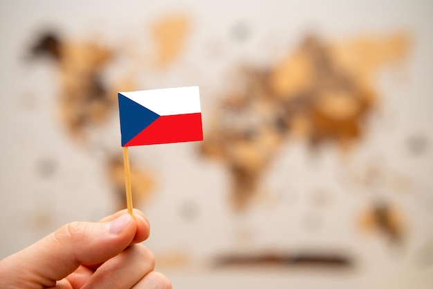 Flagge der Tschechischen Republik in der Hand des Mannes auf dem Hintergrund der Weltkarte