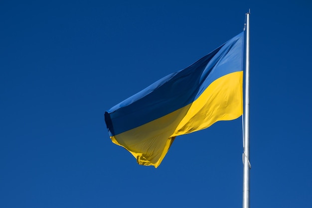 Flagge der Ukraine flattert im blauen Himmel Große gelb-blaue ukrainische Nationalstaatsflagge Krieg