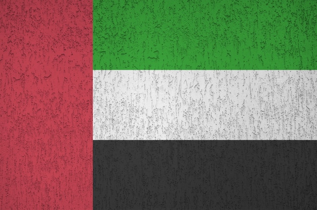 Flagge der Vereinigten Arabischen Emirate in leuchtenden Farben auf der alten Reliefputzwand abgebildet. Strukturiertes Banner auf rauem Hintergrund