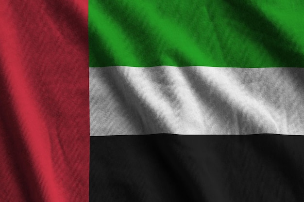 Flagge der Vereinigten Arabischen Emirate mit großen Falten, die in der Nähe unter dem Studiolicht im Innenbereich winken Die offiziellen Symbole und Farben im Banner