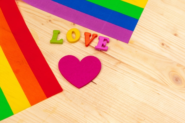 Flagge des homosexuellen Stolzes auf Holztisch