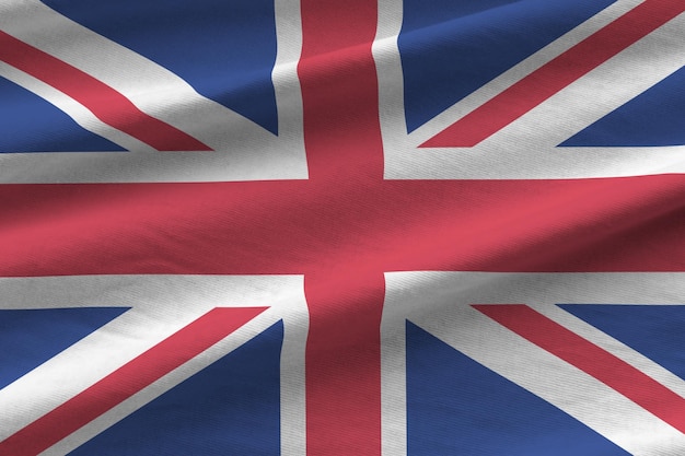 Foto flagge großbritanniens mit großen falten, die in der nähe unter dem studiolicht im innenbereich winken die offiziellen symbole und farben im banner