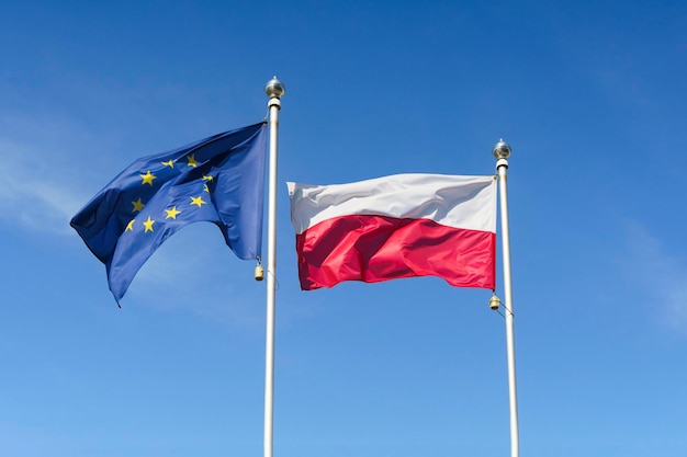 Flagge Polens und der Europäischen Union gegen den Himmel EU und Polen Konzept hochwertiges Foto