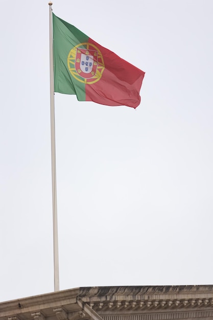 Flagge Portugals auf dem Hintergrund eines grauen Himmels