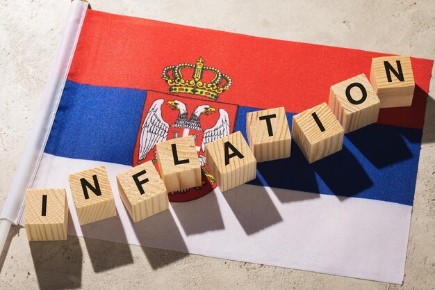 Flagge Serbiens und Holzwürfel mit Text ein Konzept zum Thema Inflation im Land
