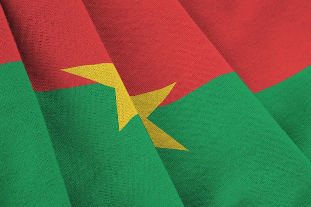 Flagge von Burkina Faso mit großen Falten, die unter dem Studiolicht im Innenbereich winken Die offiziellen Symbole und Farben im Banner