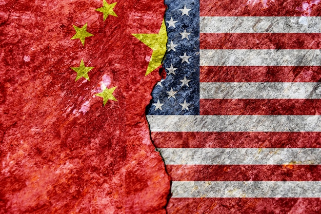 Flagge von USA und von China auf gebrochenem Betonmauerhintergrund. Konzeptkonflikte zweier Supermächte.