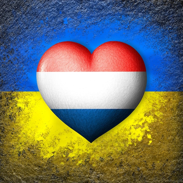 Flaggen der Ukraine und der Niederlande Flaggenherz auf dem Hintergrund der ukrainischen Flagge