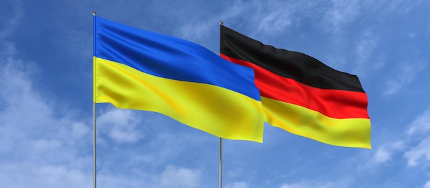 Flaggen der Ukraine und Deutschlands auf Fahnenmasten in der Mitte Flaggen am Himmelshintergrund Platz für Text Ukrainisch Deutsch 3D-Darstellung