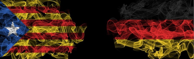 Flaggen von Katalonien und Deutschland. Rauchfahnen Katalonien vs. Deutschland