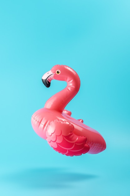 Flamingo de juguete de piscina inflable en una pared azul