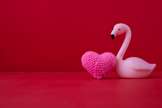 Flamingo mit rosa Herzen auf rotem copyspace