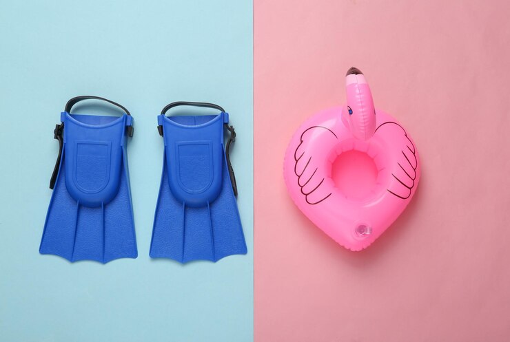 Foto flamingo rosa inflável e bebês de barbatanas de mergulho em fundo rosa-azul