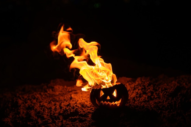 Flammenzungen in einer brennenden Kürbislaterne auf schwarzem Hintergrund Halloween-Symbol auf dem Boden Süßes oder Saures aus nächster Nähe