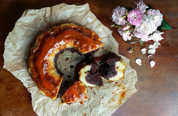 flan de chocolate, chocoflan mexicano, bizcocho de chocolate y flan de caramelo con salsa de caramelo encima, sobre una mesa de madera oscura