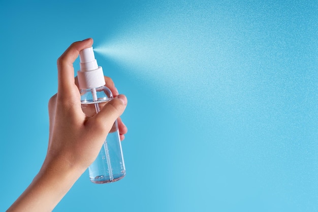 Flasca de cosméticos transparente com líquido de pulverização em fundo azul
