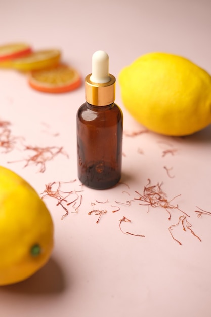 Flasche ätherisches Öl und Zitrone auf gelbem Hintergrund