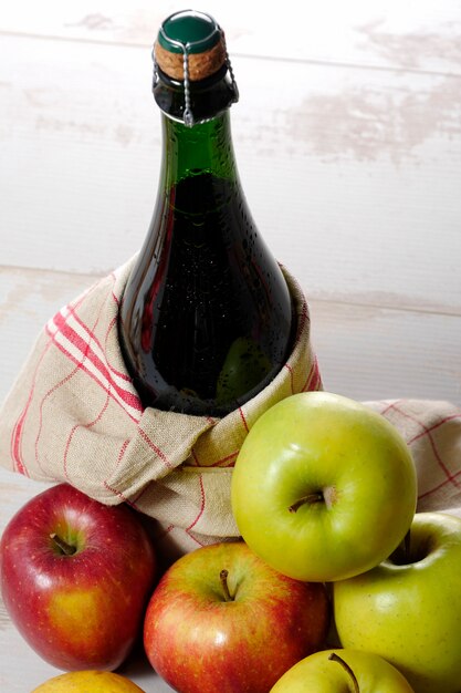 Flasche Apfelwein mit den gelben und roten Äpfeln