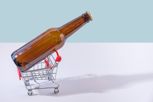 Flasche Bier in kleinem Einkaufswagen