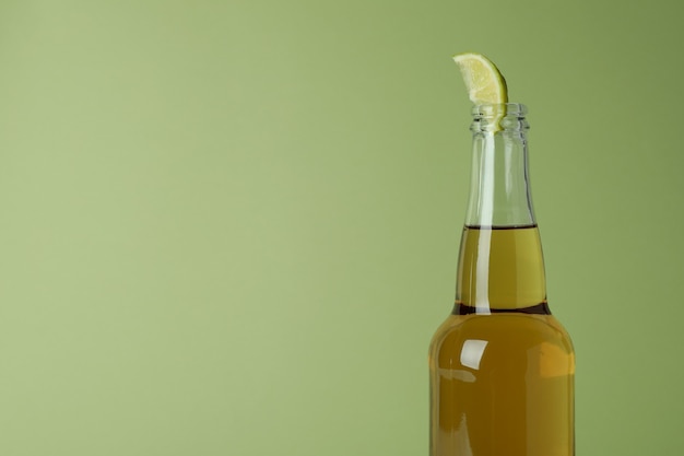 Flasche Bier mit Limettenscheibe gegen Grün