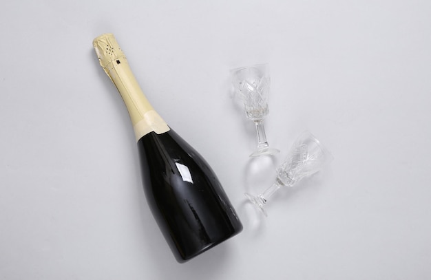 Flasche Champagner oder Wein mit Gläsern auf grauem Hintergrund
