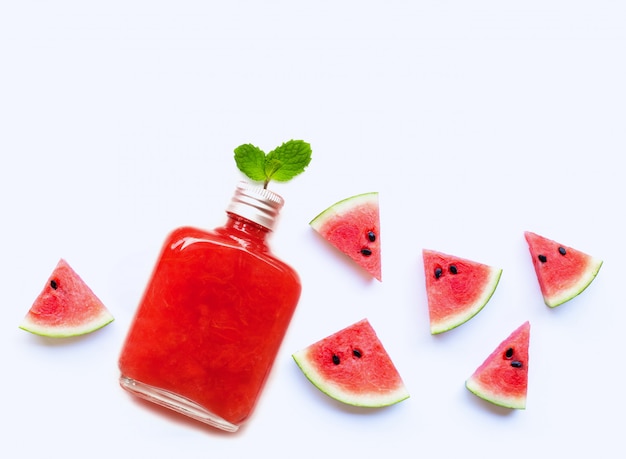 Flasche gesunder Wassermelonensaft mit der Scheibe und tadellosen Blättern lokalisiert auf Weiß