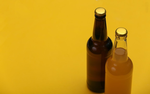 Foto flasche helles und dunkles bier auf gelbem hintergrund.