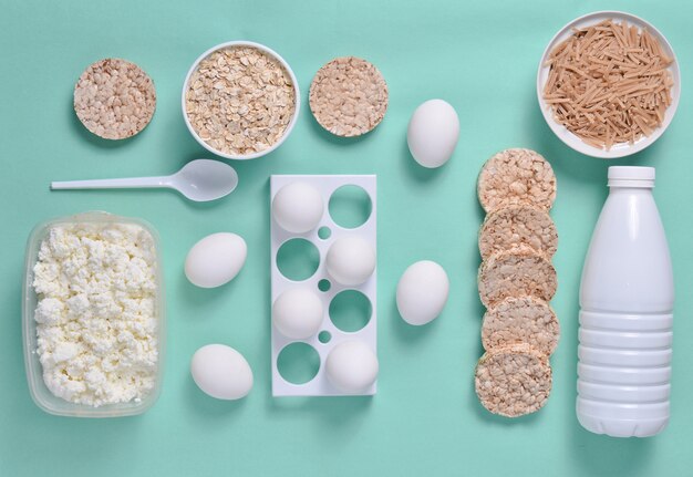 Flasche Joghurt, knuspriges rundes Brot, Buchweizennudeln, Haferflocken, Hüttenkäse, Eierablage