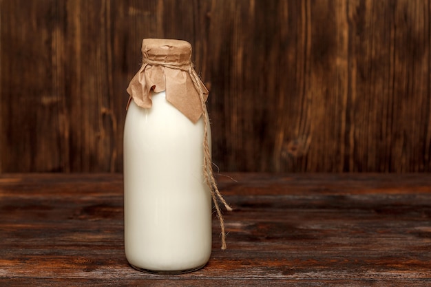 Flasche Milch auf rustikalem Holztisch