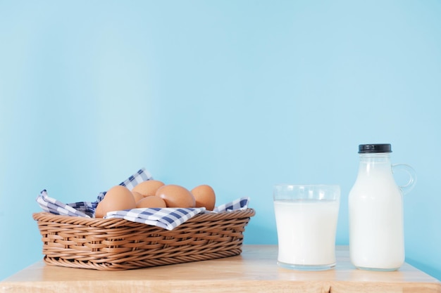 Flasche Milch und ein Glas auf Holztisch.