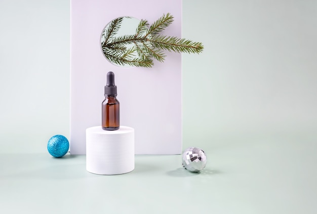 Flasche mit einer Ölpipette auf einem runden Podest Weihnachtsbaum spielt einen Zweig einer Tanne