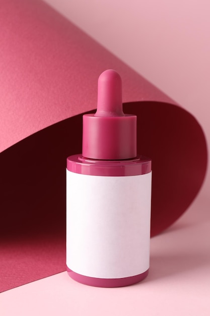 Flasche mit Hautpflegeprodukt auf rosa Hintergrund
