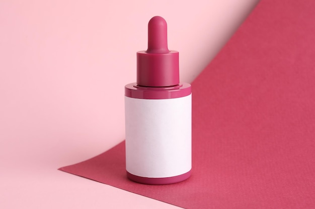 Flasche mit Hautpflegeprodukt auf rosa Hintergrundraum für Text