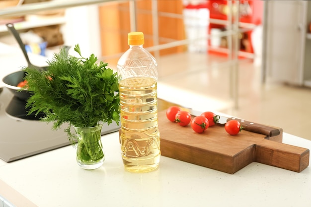 Flasche mit Kochöl und Zutaten auf dem Tisch