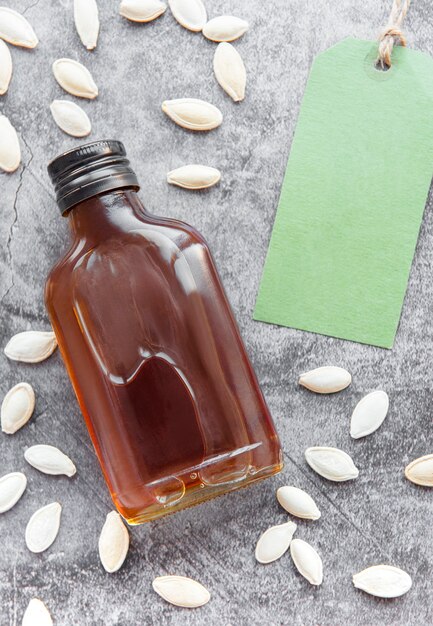 Flasche mit Kürbiskernöl auf grauer Betonoberfläche