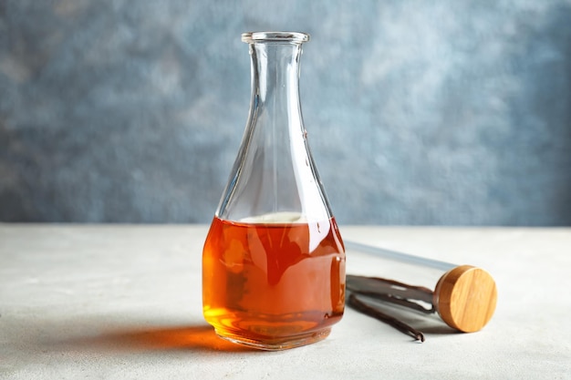 Flasche mit Vanilleextrakt und Stöcken auf dem Tisch