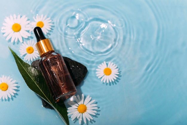 Flasche Naturkosmetik mit Blumen auf einem Hintergrund von Wasser mit Wellen. Kosmetik für den Körper