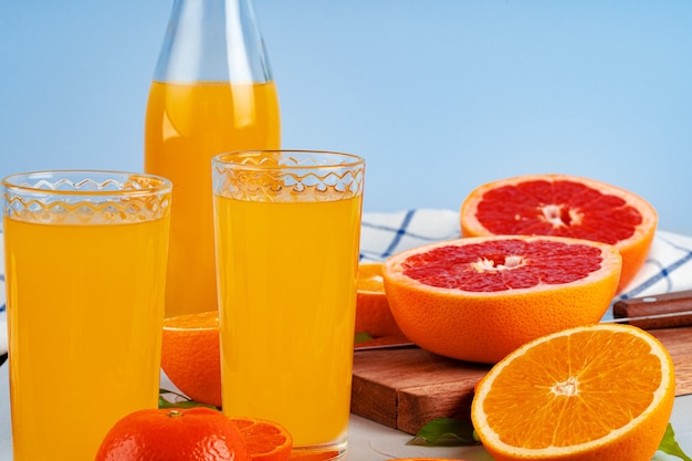 Flasche Orangensaft und frische Orangen auf dem Tisch