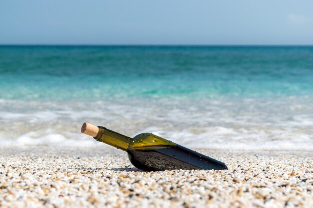 Flasche Rotwein am Strand am sonnigen Sommertag