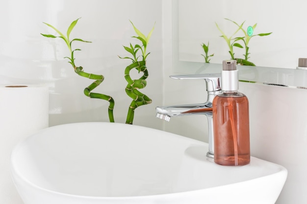 Flasche Seife auf Waschbecken in weißem, modernem Badezimmer-Interieur Konzept zur Prävention von Bakterieninfektionen