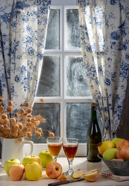 Flasche und Gläser Apfelwein mit Äpfeln. Im rustikalen Haus Fensterhintergrund