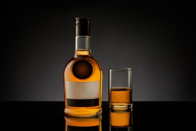 Flasche und Glas mit Whisky-Cognac-Brandy auf schwarzem Hintergrund