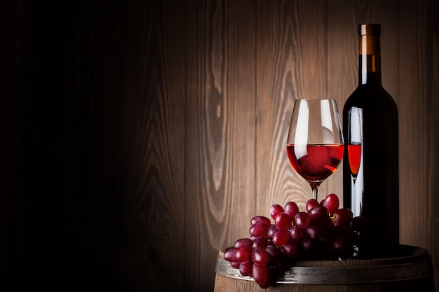 Flasche und Glas Rotwein mit Trauben