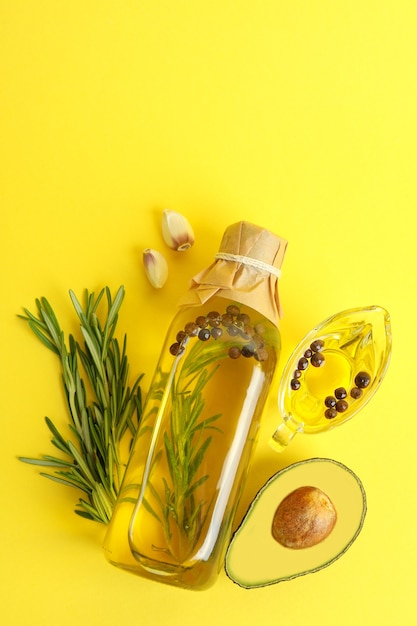 Flasche und Sauciere Öl und Zutaten auf gelbem Hintergrund