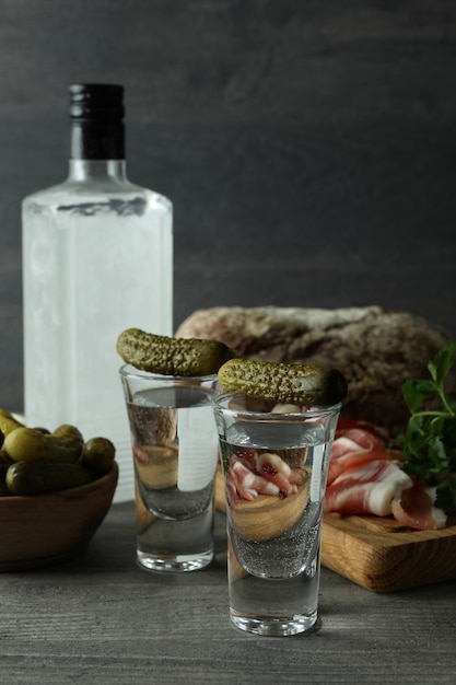 Flasche und Wodka und verschiedene Snacks auf grauem Tisch