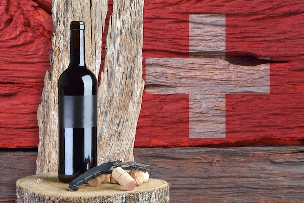 Flasche Wein mit Schweizer Flagge im Hintergrund