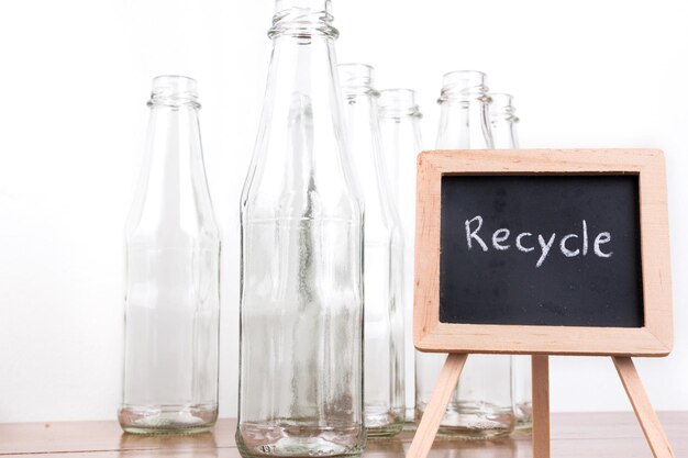 Flaschen mit dem Text "Recycle" auf der Tafel auf weißem Hintergrund