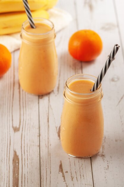 Flaschen mit Mandarine und Bananen-Smoothie