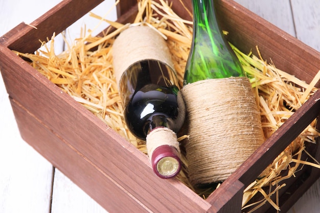 Flaschen Wein in Holzkiste auf Holzhintergrund